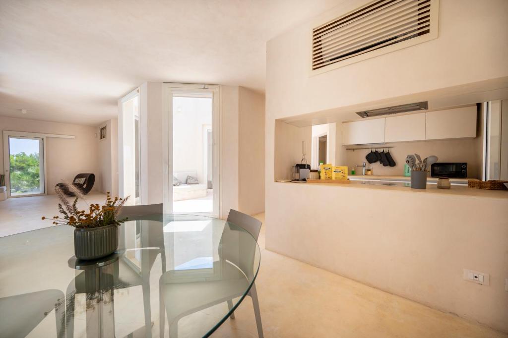 une salle à manger avec une table en verre et une cuisine dans l'établissement Sky Dream Oasi Vendicari - Sicilia Vacanza, à Casa Maccari