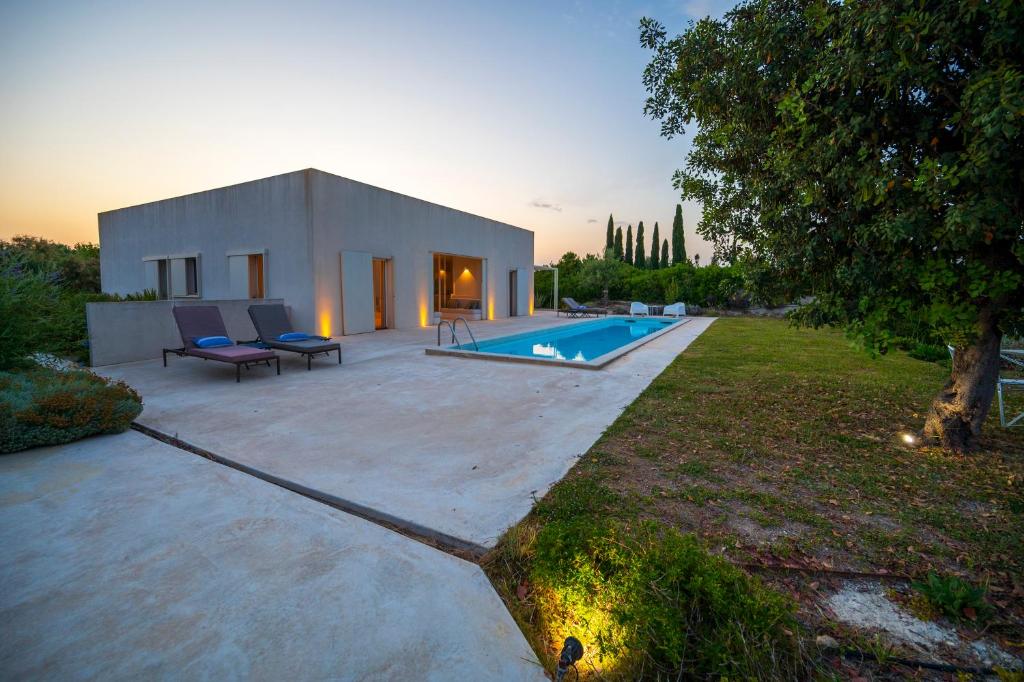 une petite maison blanche avec une piscine dans une cour dans l'établissement Sky Dream Oasi Vendicari - Sicilia Vacanza, à Casa Maccari