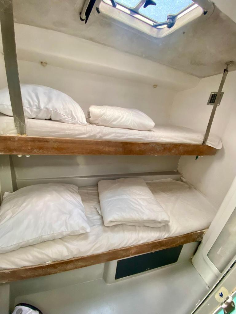 deux lits superposés dans un bateau avec des oreillers blancs dans l'établissement BOAT PARADISE LA ROCHELLE - Cranchi Méditerranée 40, à La Rochelle