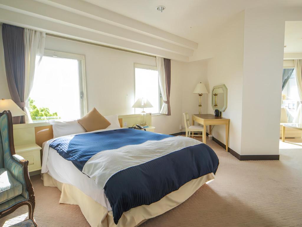 une chambre d'hôtel avec un grand lit et un bureau dans l'établissement LiVEMAX RESORT Setouchi Sea Front, à Tatsuno