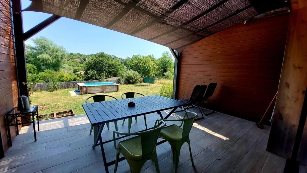 une grande véranda avec une table et des chaises dans l'établissement L'Odyssée 07/ Gîte Ardèche, à Saint-Paul-le-Jeune