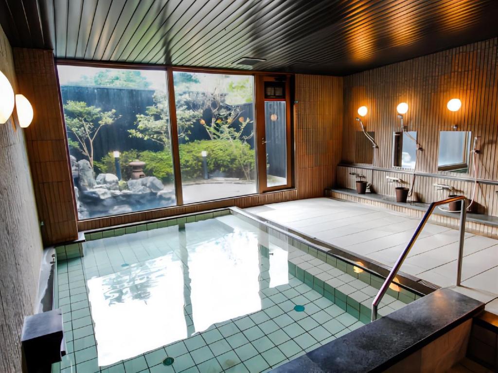 - une piscine dans une chambre dotée d'une grande fenêtre dans l'établissement LiVEMAX RESORT Kyotango Sea Front, à Kyōtango