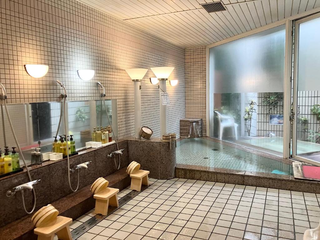 une grande salle de bains avec une baignoire et une piscine dans l'établissement LiVEMAX RESORT Setouchi Sea Front, à Tatsuno