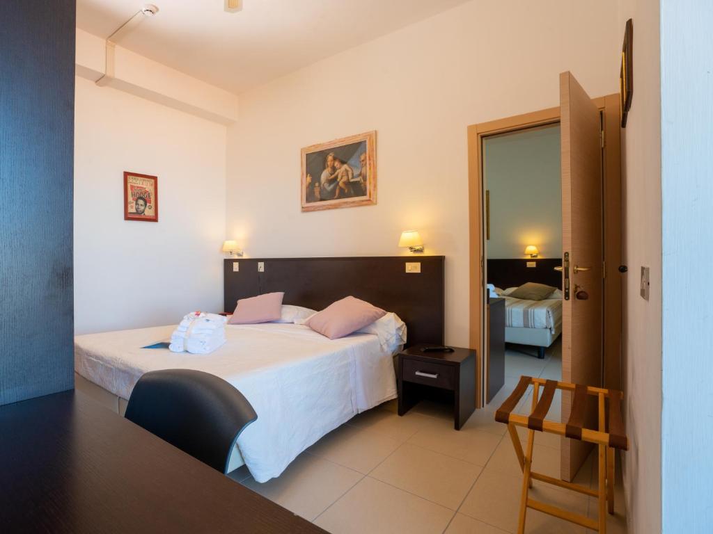 une chambre d'hôtel avec un lit et un miroir dans l'établissement Hotel Ancore, à Senigallia