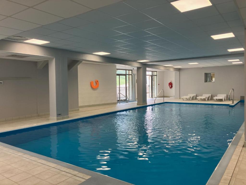 une piscine avec de l'eau bleue dans un immeuble dans l'établissement Résidence Mer & Golf Tourmalet, à La Mongie