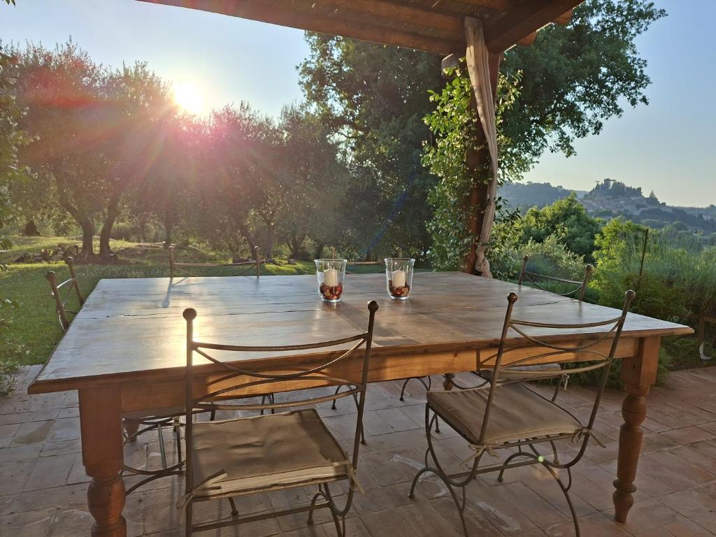 - une table en bois avec des chaises et des verres sur la terrasse dans l'établissement Il Poggio - Luxury villa in Tuscany, à Cetona 7 autres photos