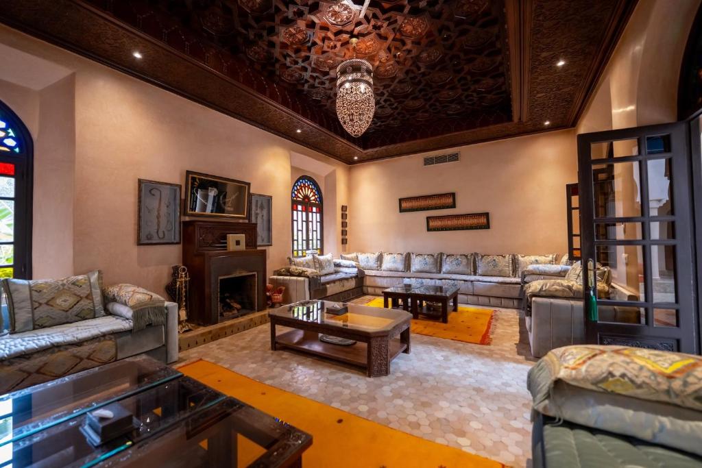 un grand salon avec des canapés et une cheminée dans l'établissement Al Fassia Aguedal, à Marrakech