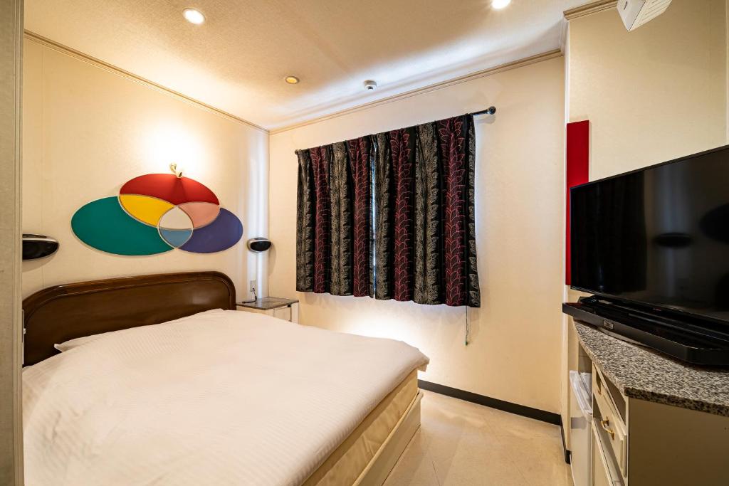 une petite chambre avec un lit et une télévision à écran plat dans l'établissement Hotel Hu Namba (Adult Only), à Osaka