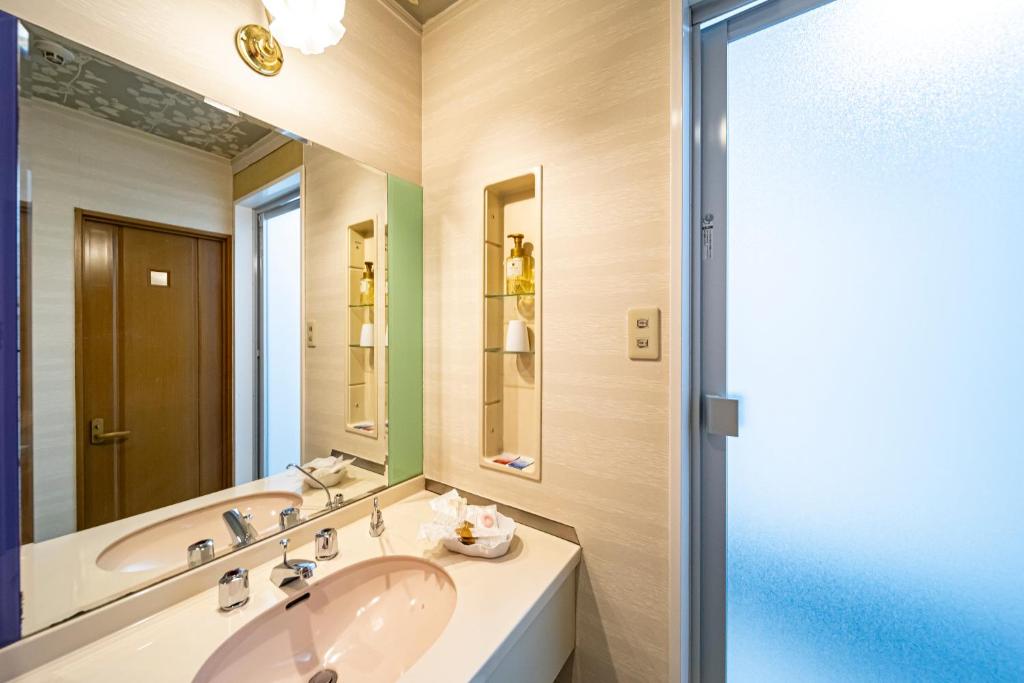 une salle de bain avec un lavabo et un miroir dans l'établissement Hotel Hu Namba (Adult Only), à Osaka