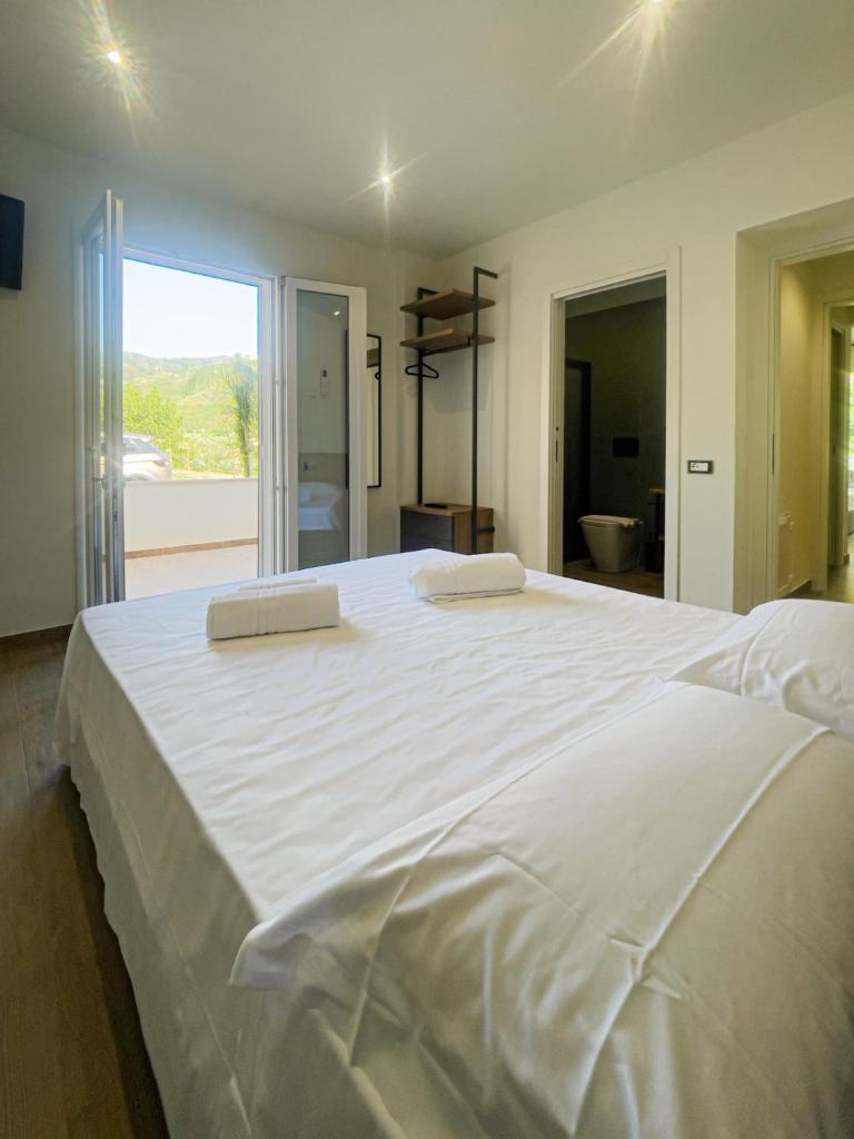 - un grand lit blanc avec 2 oreillers dans l'établissement The Villa - Lascari Cefalu', à Lascari