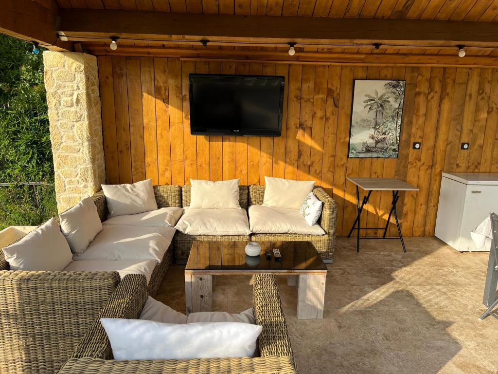 un salon avec des canapés et une télévision à écran plat dans l'établissement terrain avec Mobil-Home, à Sommières