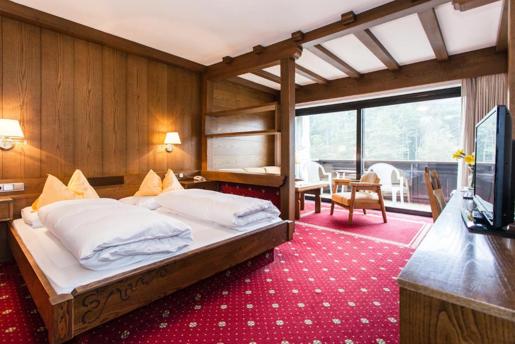 - une chambre avec un lit et une télévision dans l'établissement Hotel Am Wolfgrubenersee, à Soprabolzano