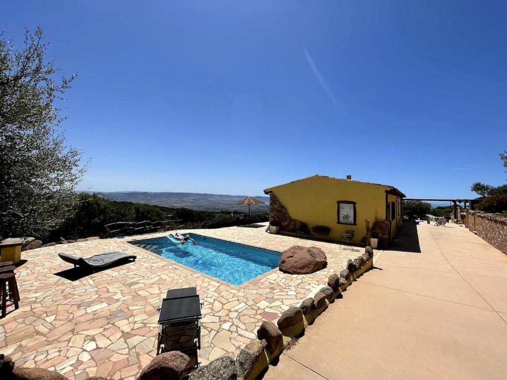 une piscine dans une cour avec une maison dans l'établissement Casa Golfo Asinara,Ocean view, private pool, fully air-conditioned, secluded location, à Trinità d'Agultu e Vignola