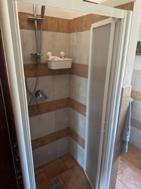 La salle de bains est pourvue d'une douche et d'une porte ouverte. dans l'établissement Casa Golfo Asinara,Ocean view, private pool, fully air-conditioned, secluded location, à Trinità d'Agultu e Vignola 28 autres photos