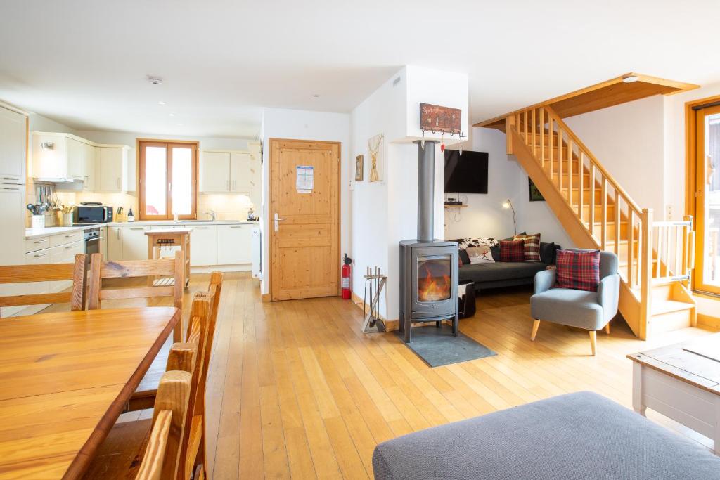 - un salon avec un canapé, une table et une cheminée dans l'établissement Simply Morzine - Chalet Coeur de Morzine, à Morzine