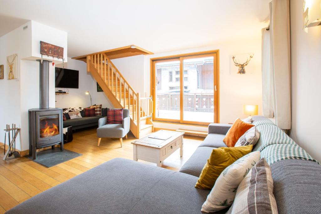 un salon avec un canapé et une cheminée dans l'établissement Simply Morzine - Chalet Coeur de Morzine, à Morzine 37 autres photos