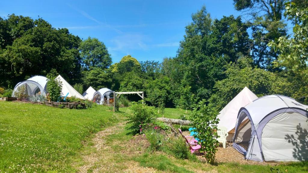 un groupe de tentes dans un champ arboré dans l'établissement Tente insolite en pleine nature, à Tréduder 16 autres photos