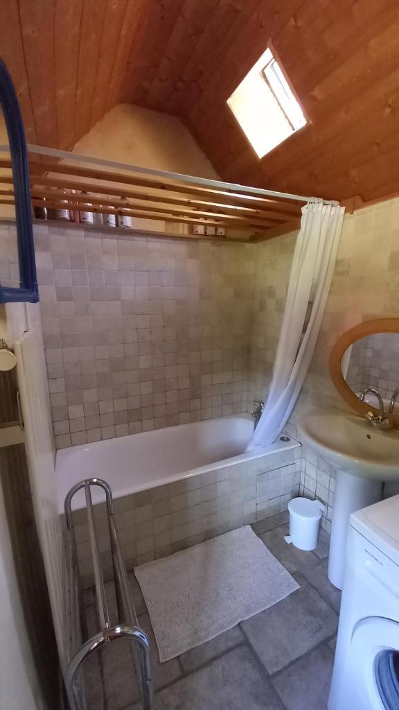 une salle de bain avec une baignoire et un lavabo dans l'établissement Tente insolite en pleine nature, à Tréduder
