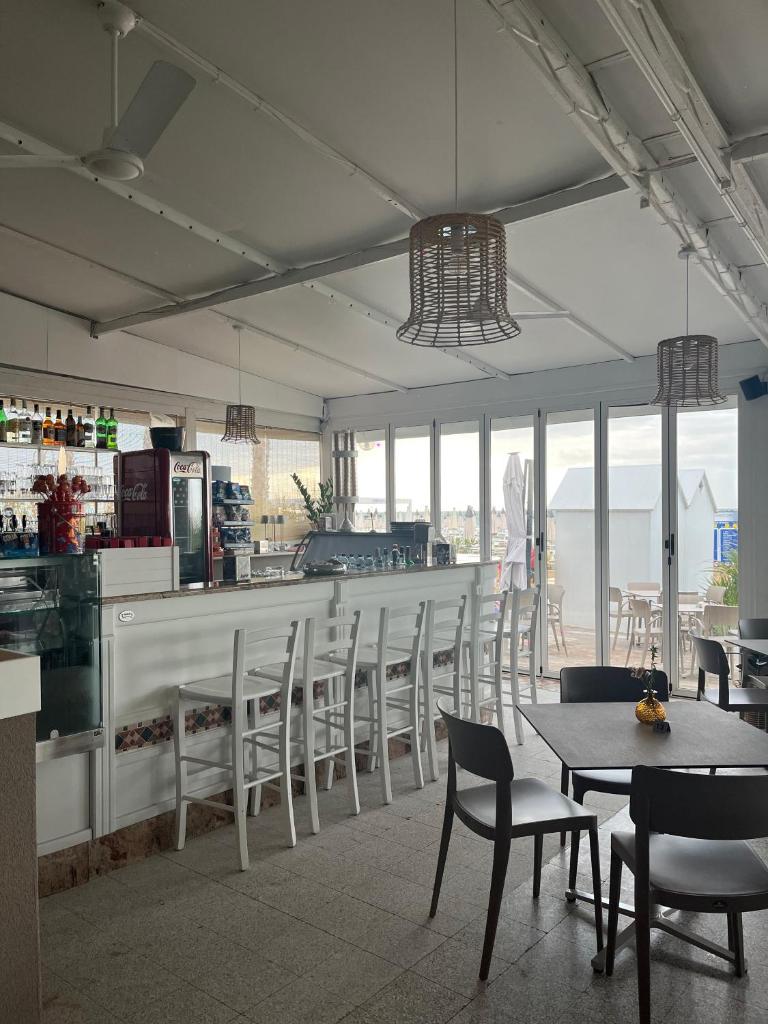 un restaurant avec un bar avec des chaises et une table dans l'établissement Hotel Silva Frontemare, à Lido di Jesolo
