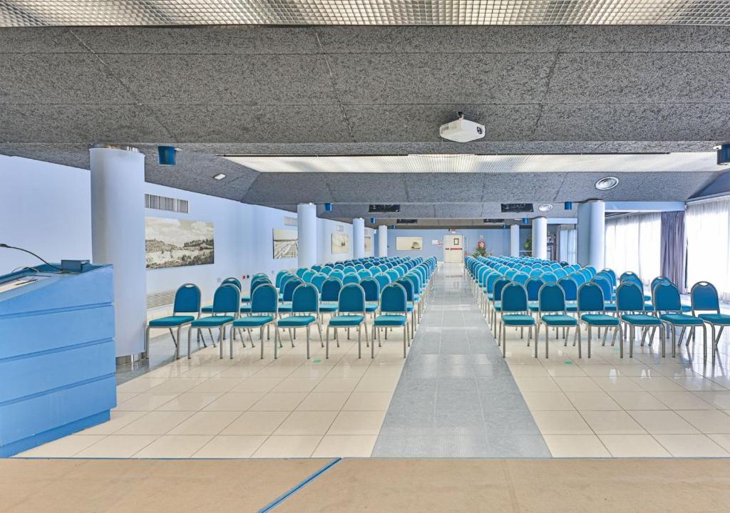 une salle de conférence avec des chaises bleues dans un bâtiment dans l'établissement Grand Hotel Continental, à Tirrenia 51 autres photos