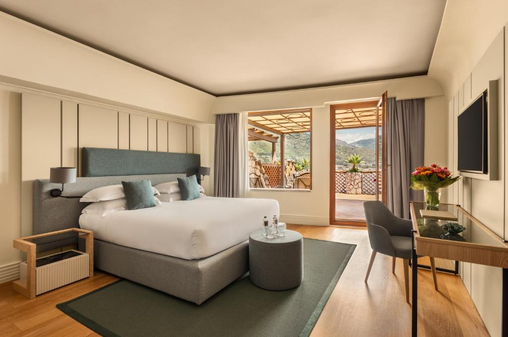 une chambre avec un lit, une table et une chaise dans l'établissement Atlantis Bay - VRetreats, à Taormine