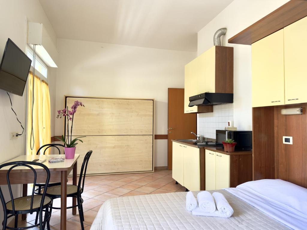 une chambre avec un lit et une table et une cuisine dans l'établissement Residence Carioca, à Rimini