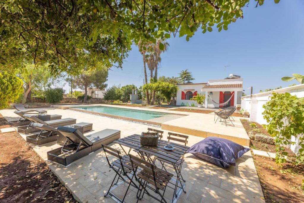 - une piscine avec des chaises et une table à côté d'une maison dans l'établissement Villa Tre Palme, à Castrignano del Capo