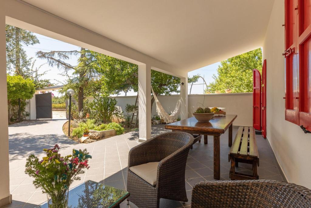 un patio extérieur avec une table et des chaises en bois dans l'établissement Villa Tre Palme, à Castrignano del Capo