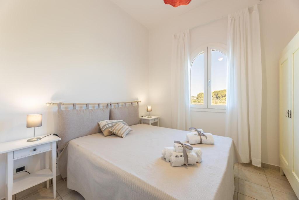 une chambre blanche avec un lit blanc et une fenêtre dans l'établissement Villa Tre Palme, à Castrignano del Capo