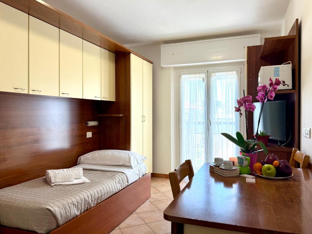 une chambre avec un lit et un bureau avec une table avec des fruits dans l'établissement Residence Algarve, à Rimini