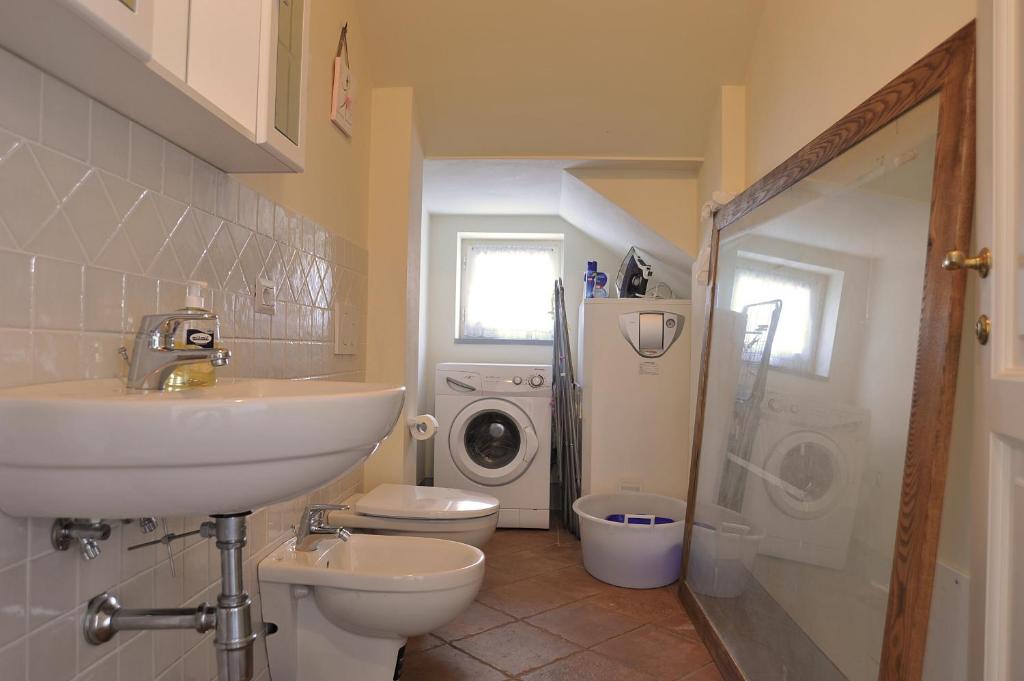 une salle de bain avec un lavabo et une machine à laver dans l'établissement Casa Rosa, à Greve in Chianti