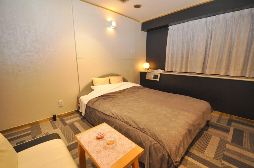 une petite pièce avec un lit et une table dans l'établissement Hotel Boston Club (Adult Only), à Tokyo