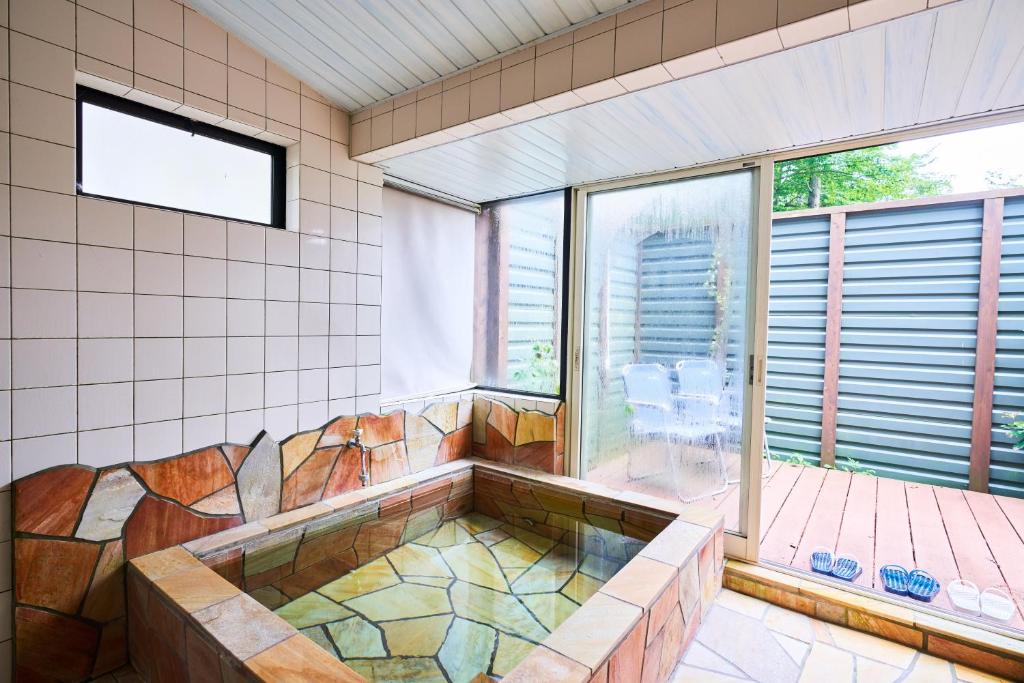 une salle de bain avec une baignoire et une fenêtre dans l'établissement Manor House, à Yamanakako