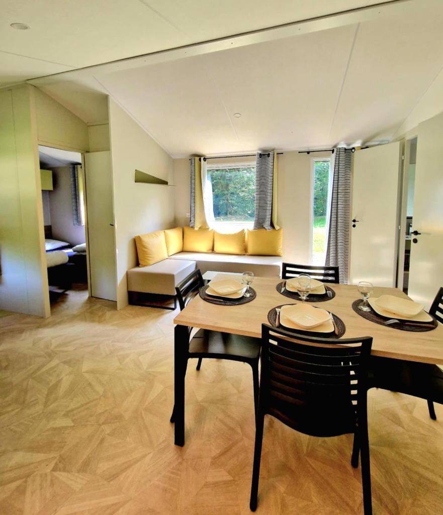 un salon avec une table, des chaises et un canapé dans l'établissement Camping de la Bonnette, à Caylus