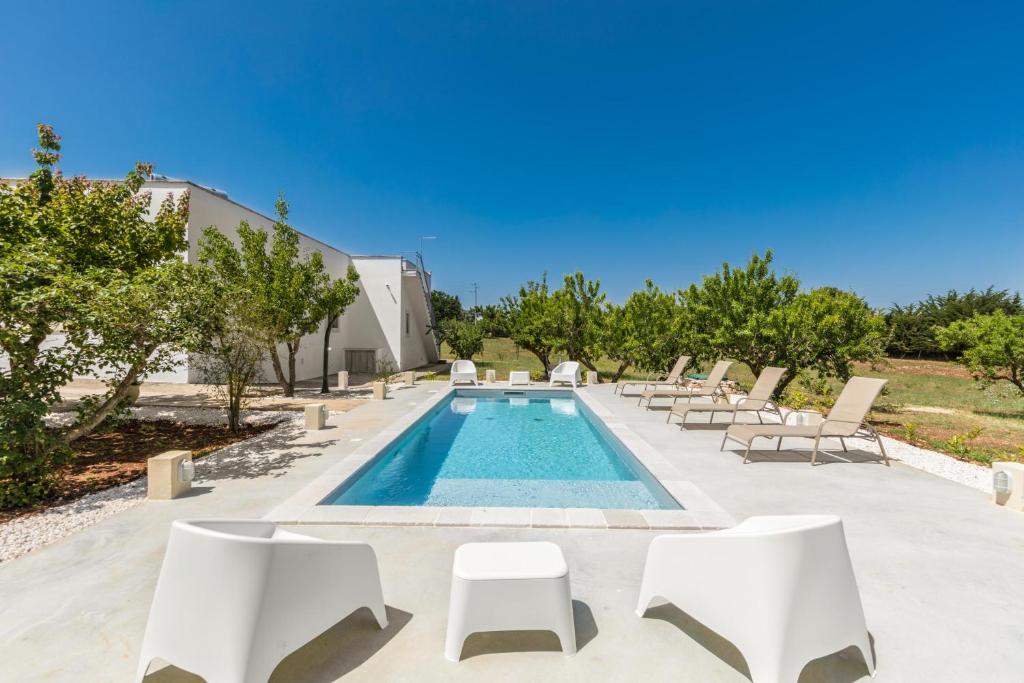 - une piscine avec des chaises longues et un salon de natation dans l'établissement Villa Il sogno di Marghy by Perle di Puglia, à Cisternino