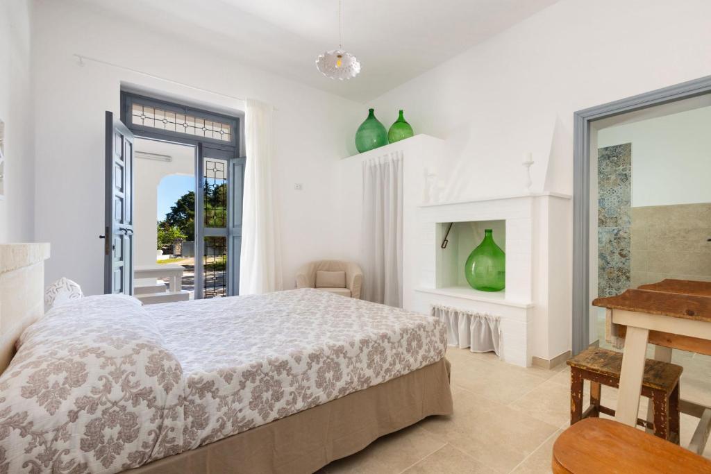 une chambre blanche avec un lit et une table dans l'établissement Villa Il sogno di Marghy by Perle di Puglia, à Cisternino