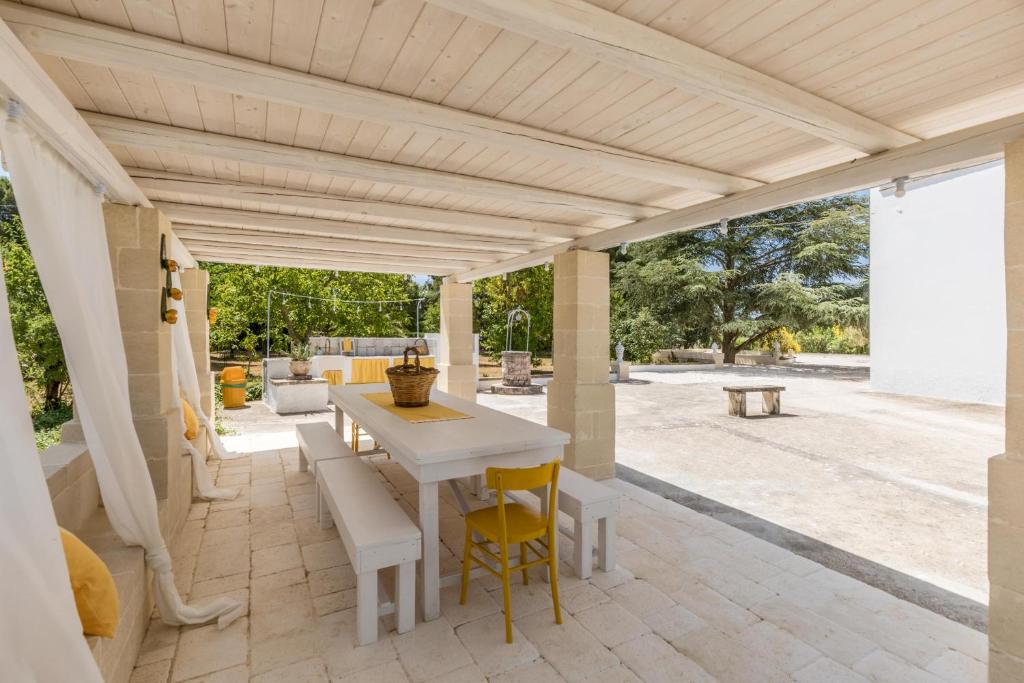 une terrasse avec une table et des chaises blanches dans l'établissement Villa Il sogno di Marghy by Perle di Puglia, à Cisternino