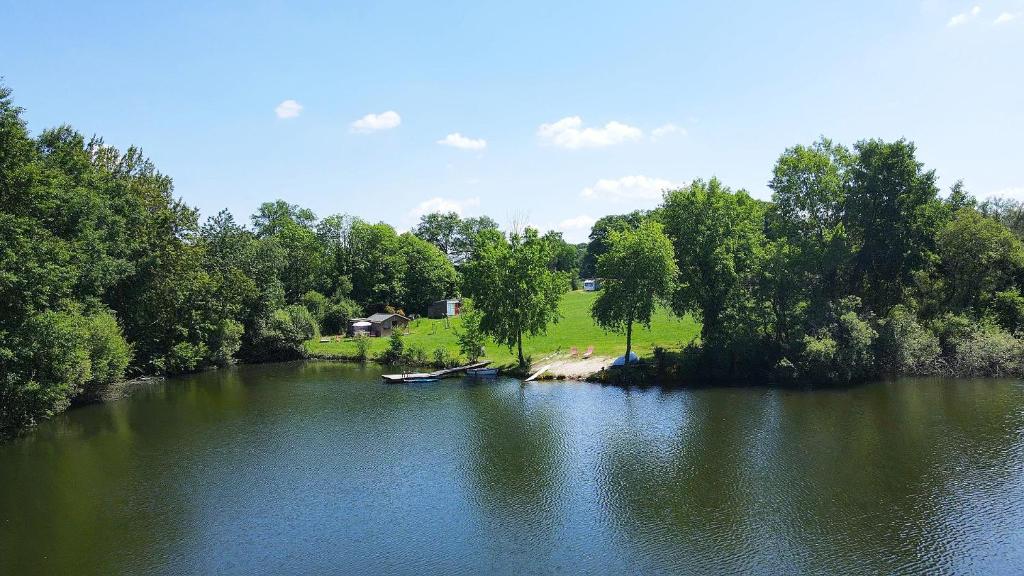 une vue aérienne sur une rivière avec des arbres et une maison dans l'établissement Caravanne 4 Pers Vue Sur L'étang, à Champsac