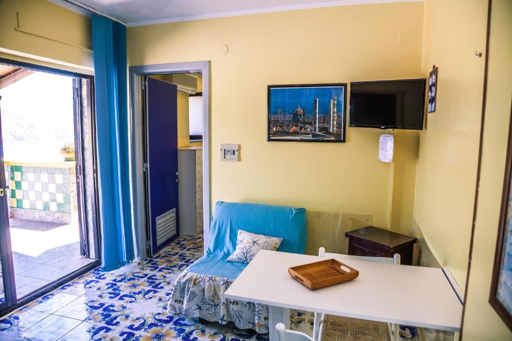 Cette petite chambre comprend une table et un canapé. dans l'établissement Le Terrazze Palinuro, à Palinuro