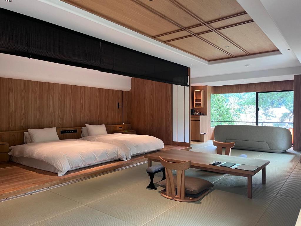 une chambre avec un grand lit et une table dans l'établissement Sekizenkan Kashotei Sanso, à Nakanojo