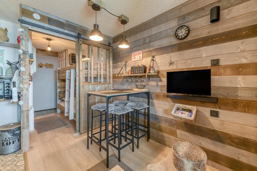 - un bar avec tabourets dans une pièce dotée de murs en bois dans l'établissement Studio Montagnard Vue Splendide, à L'Alpe-d'Huez 15 autres photos