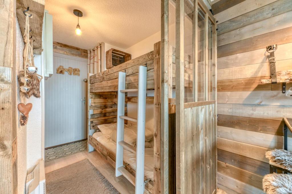 Ce lit superposé se trouve dans un dortoir doté de murs en bois. dans l'établissement Studio Montagnard Vue Splendide, à L'Alpe-d'Huez