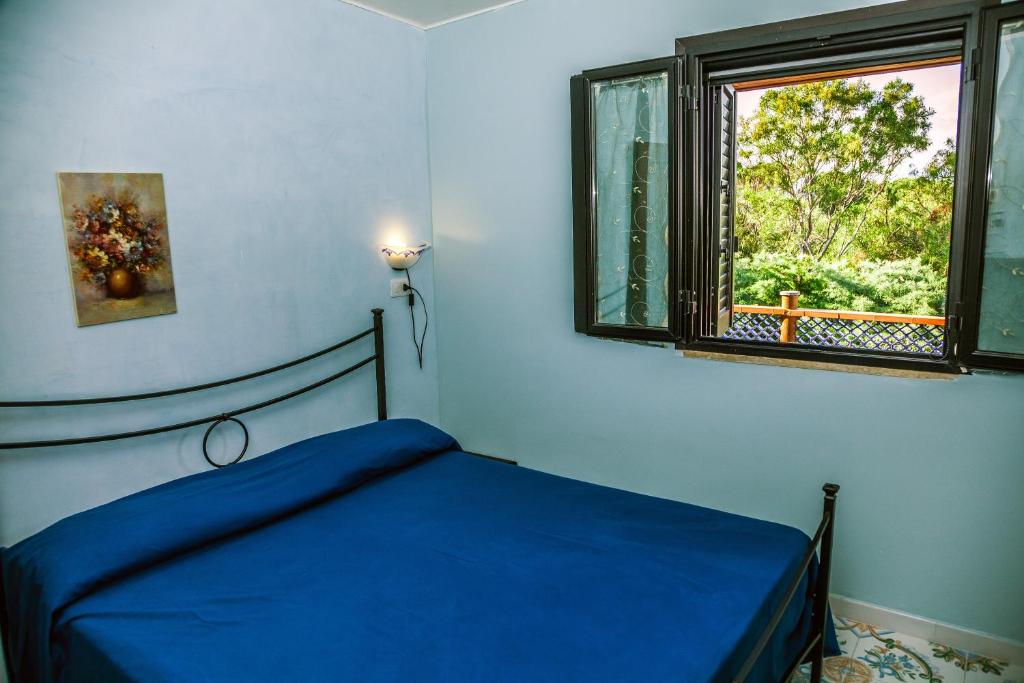 une chambre avec un lit bleu et une fenêtre dans l'établissement Le Terrazze Palinuro, à Palinuro 120 autres photos
