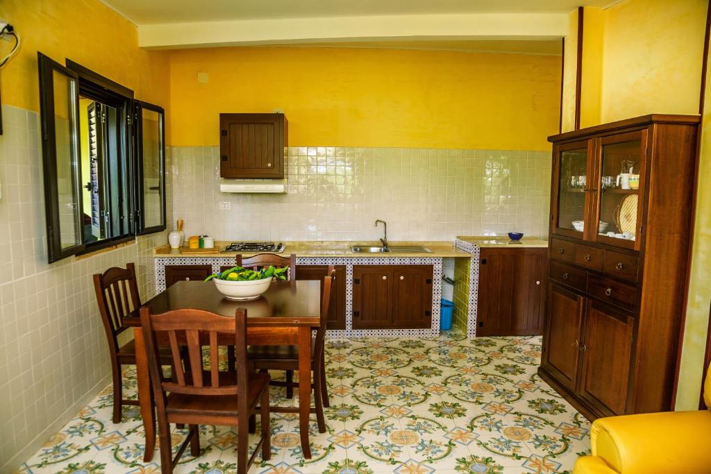 une cuisine avec une table, des chaises et un évier dans l'établissement Le Terrazze Palinuro, à Palinuro