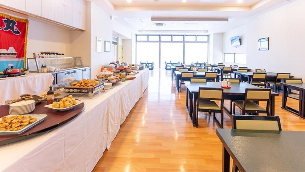 une cafétéria avec des tables et des chaises et de la nourriture dans l'établissement LiVEMAX RESORT Shiretoko Sea Front, à Rausu