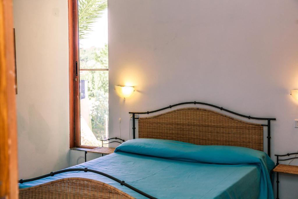 Ce lit se trouve dans un dortoir doté d'une fenêtre et d'un couvre-lit. dans l'établissement Le Terrazze Palinuro, à Palinuro