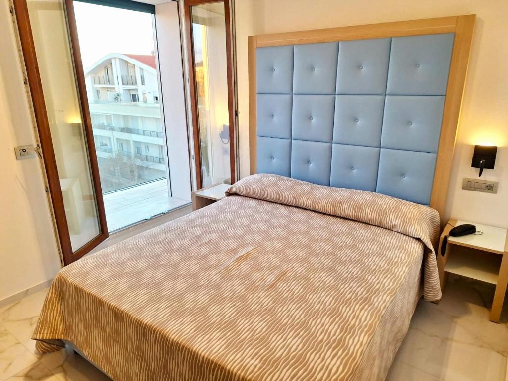 une chambre avec un grand lit et une grande fenêtre dans l'établissement Hotel La Margherita & SPA, à Alghero 77 autres photos