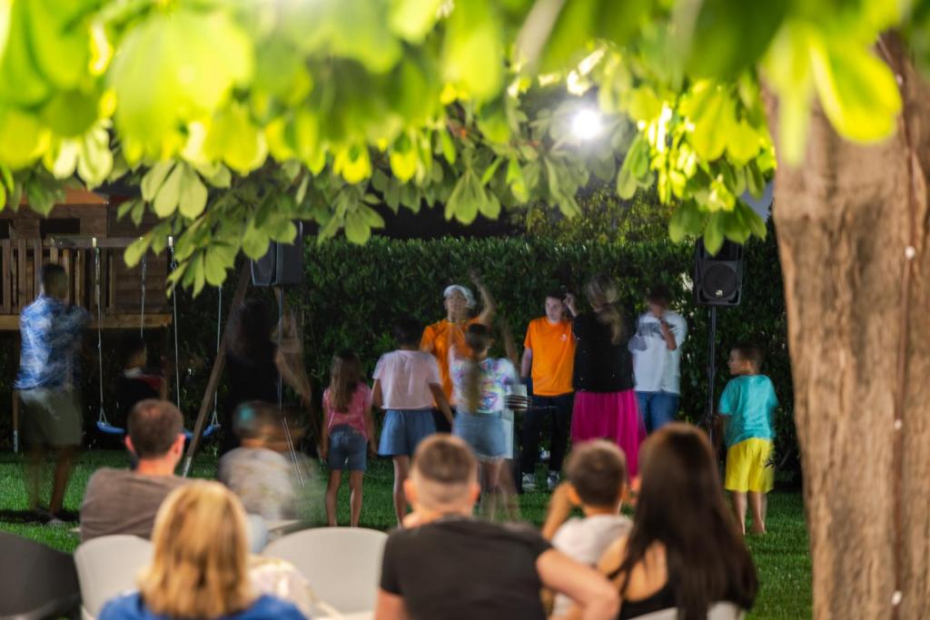 un groupe de personnes regardant un spectacle dans un parc dans l'établissement Hotel Palace Magnolia SPA, à Tortoreto Lido 101 autres photos