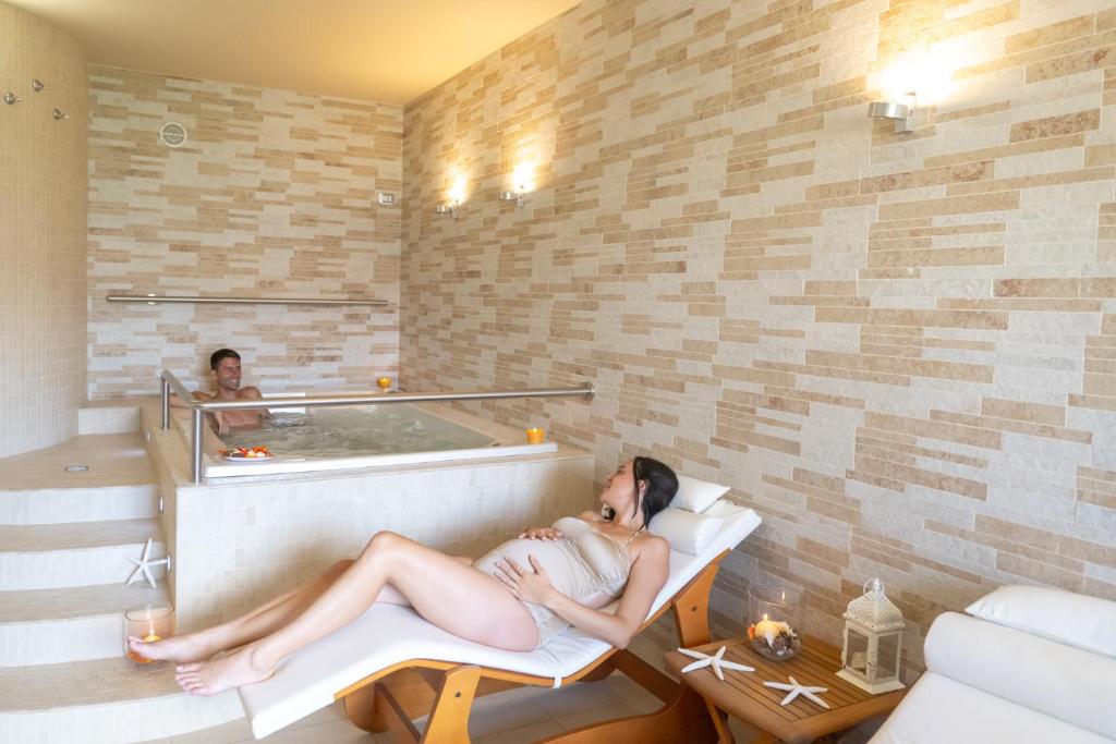 une femme qui se couche dans une baignoire dans une pièce dans l'établissement Hotel Palace Magnolia SPA, à Tortoreto Lido