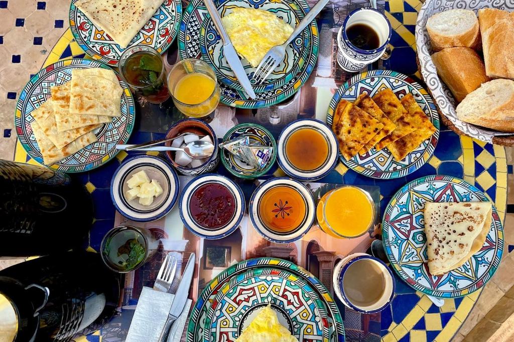 une table avec des assiettes de petits-déjeuners et de boissons dans l'établissement Riad Rayhane Fes, à Fès